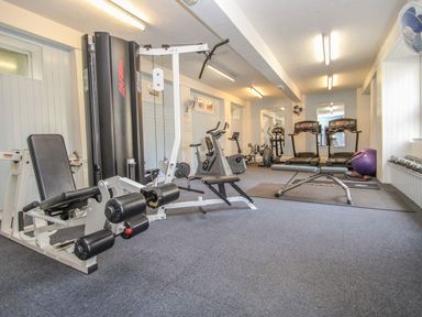 A gym room with exercise machines treadmills a bench and weights at 59 Valley Lodge in Callington near Gunnislake