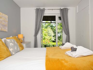 A bedroom with a bed with yellow and grey pillows and folded towels on a yellow blanket at 59 Valley Lodge in Callington near Gunnislake