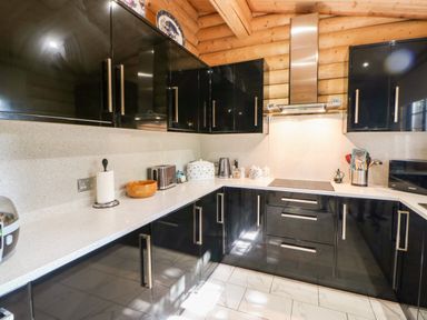 A kitchen with black cabinets a kettle toaster and paper towel on the counter at Jalan End in Felton