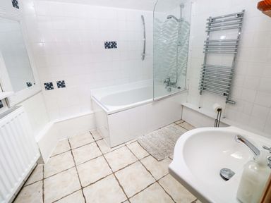 A bathroom with a bathtub, shower, sink, and mirror at The Nook in Star near Cenarth