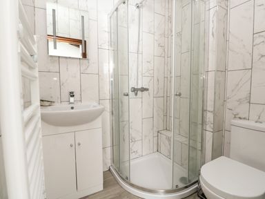 A bathroom with a sink cabinet mirror shower enclosure and toilet at The Brewery in Brewers Quay Harbour
