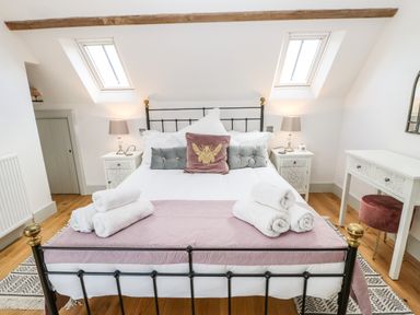 A bedroom with a metal bed frame pillows bedside tables lamps and a dressing table at Greystead Institute in Bellingham