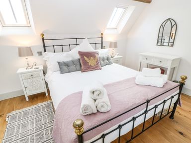 A bedroom with a bed pillows bedside tables lamps rug and a mirror at Greystead Institute in Bellingham