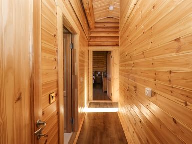 A wooden hallway with doors leading to rooms at Rowan Lodge in Greetham Rutland