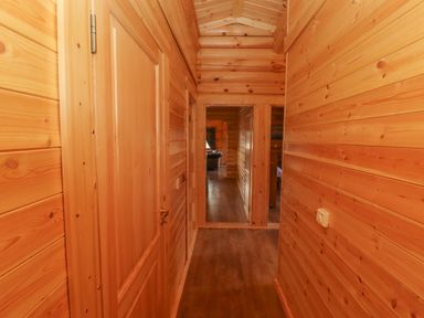 A wooden hallway with doors and a wooden floor at Maple Lodge in Greetham Rutland