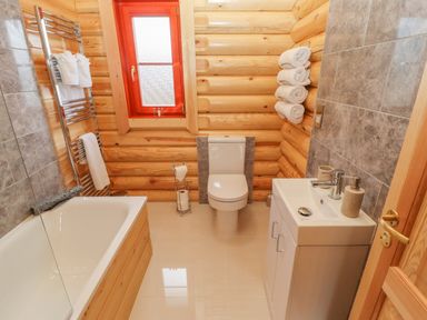 A bathroom with a bathtub sink toilet and towels at Maple Lodge in Greetham Rutland