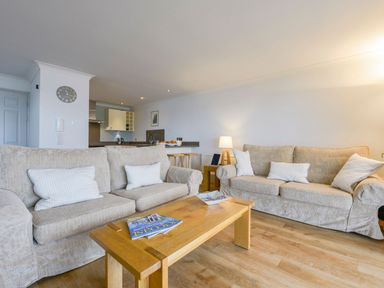 A living room with two beige sofas and a wooden coffee table at 17 Burgh Island Causeway in Bigbury-On-Sea