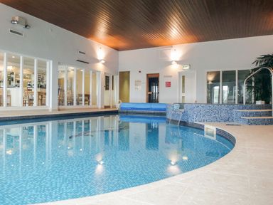 An indoor swimming pool with tiled flooring and a wooden ceiling at 17 Burgh Island Causeway in Bigbury-On-Sea