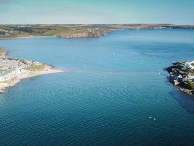 A coastal landscape with a beach parking area boats and green hills at 17 Burgh Island Causeway in Bigbury-On-Sea