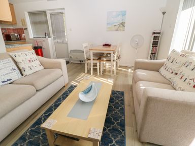 A living room with two sofas a wooden coffee table and a dining table with chairs at Ballasalla in Liskeard