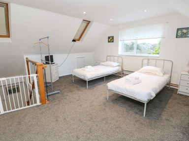 A bedroom with two single beds and a window at Alice Cottage in Wheal Kitty near St Agnes