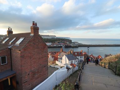 A coastal town with brick houses and stairs leading down to the harbor at Mariners Watch in Whitby