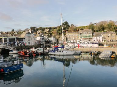 A harbor with boats docked and buildings along the waterfront at Summer Breeze in Tregolds near St Merryn