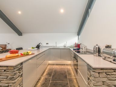 A kitchen with stone island sides and modern appliances at Boathouse on the Lake in Bowness-On-Windermere