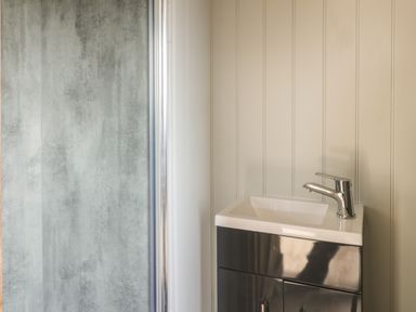 A bathroom sink next to a shower with frosted glass at Ewes Welcome in Cottingham