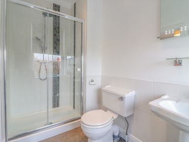 A bathroom with a shower enclosure toilet and sink at Seasides in Weymouth