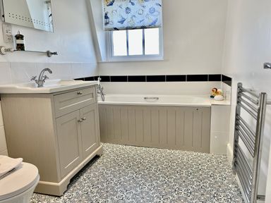 A bathroom with a sink and bath at Seasides in Weymouth