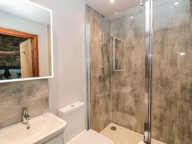 A bathroom with a sink toilet and glass shower enclosure at Granary Cottage in Bellingham