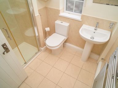 A bathroom with a shower enclosure toilet sink and tiled floor at Plumblands in Chapel Stile