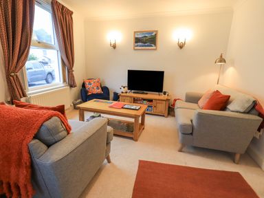 A living room with two sofas a television and a coffee table at Holme Rigg in Braithwaite