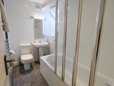 A bathroom with a toilet sink bathtub and shower screen at Holme Rigg in Braithwaite