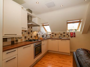 A kitchen with cabinets countertop oven stove sink and two skylight windows at Harbour Reach 6 Weymouth