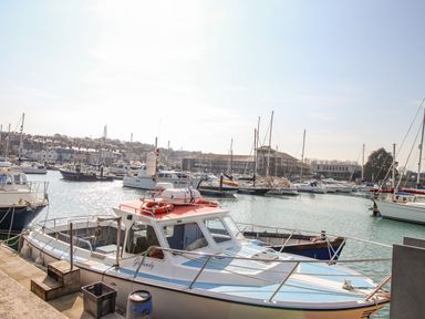 A harbor with multiple boats docked and buildings in the background at Harbour Reach 6 in Weymouth