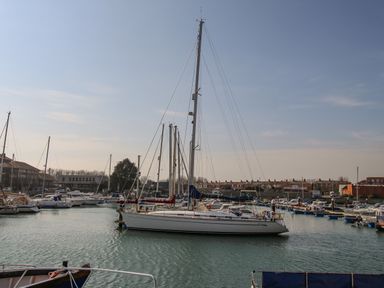 A marina with multiple sailboats and motorboats docked in the water at Harbour Reach 6 in Weymouth