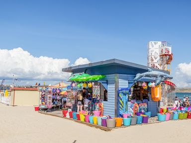 A beachside shop with colorful buckets and inflatable toys at Harbour Reach 6 in Weymouth