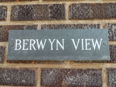 A metal sign with the text Berwyn View mounted on a brick wall at Berwyn View in Trelydan near Welshpool