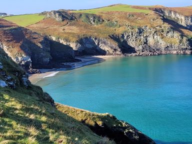 A coastal bay with turquoise water sandy beach and cliffs at Laurel Lodge in Bossiney Bay Holiday Park near Tintagel