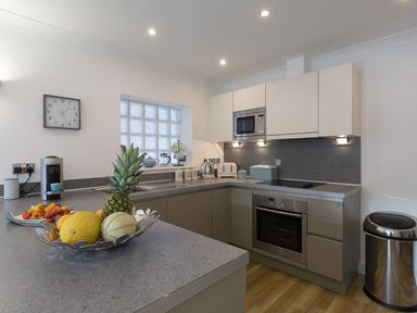 A kitchen with a fruit bowl on the counter a microwave oven sink toaster and a coffee machine at Atlantis in St Ives