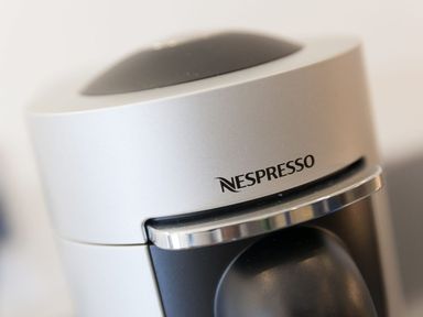 A close up of a silver and black Nespresso coffee machine