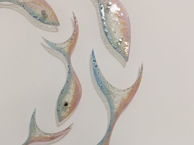 A wall decoration of abstract fish shapes with blue pink and cream colors at Atlantis in St Ives