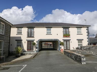 A two-story building with balconies and a driveway archway at Harbour View in Porthmadog