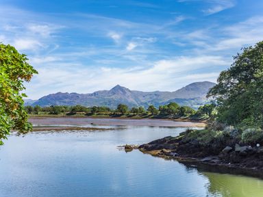 A river with trees on the banks and mountains in the background at Harbour View in Porthmadog