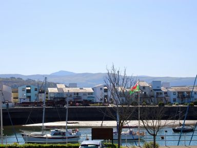 A harbor with boats on the water and modern buildings in the background at Harbour View in Porthmadog