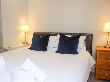 A bedroom with a bed and bedside lamps at Simples, Dartmouth