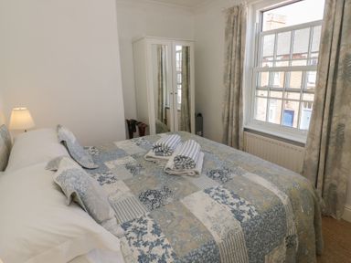 A bedroom with a bed and mirror cabinet at Heath Cottage in Stratford-Upon-Avon