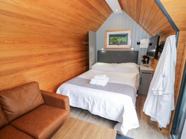 A bedroom with a bed and couch at Willow Lodge At Bridge Lake Farm & Fishery Chacombe