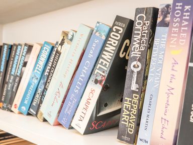 A close-up of a bookshelf with various books standing upright at Higher Kernick View in Helland near Blisland