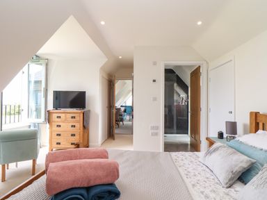 A bedroom with a bed a chest of drawers and a television at Higher Kernick View Helland near Blisland