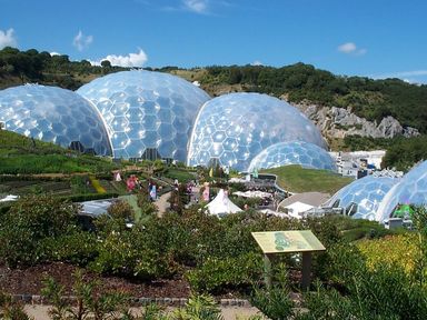 A botanical garden with large geodesic dome structures surrounded by plants and pathways at Higher Kernick View in Helland near Blisland