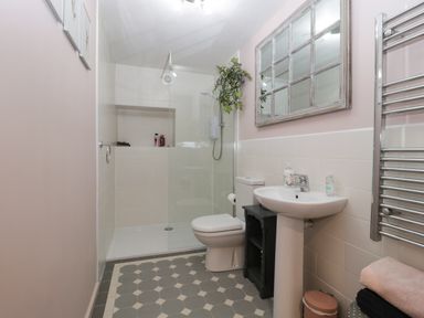 A bathroom with a walk-in shower toilet pedestal sink mirror and a heated towel rail at The Courtyard - Hilltop Barn Winterborne Zelston near Wareham