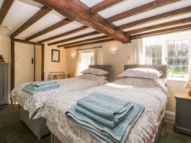A bedroom with two single beds and folded towels on each at Field View in Curland near Taunton