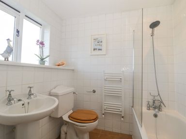 A bathroom with a sink toilet and bathtub with shower at Field View in Curland near Taunton