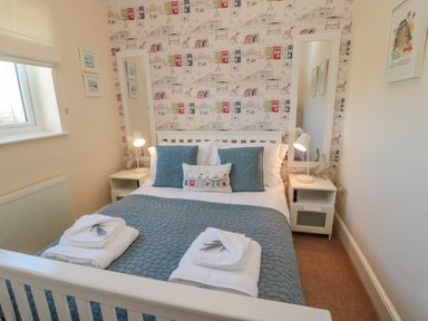 A bedroom with a double bed and bedside tables with lamps at Cushat House Stamford near Embleton