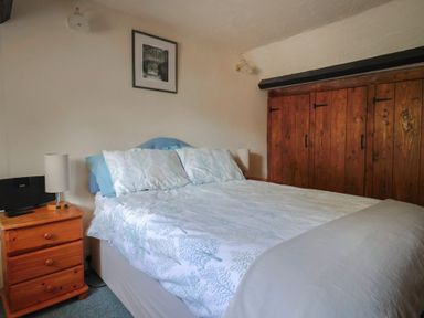 A bedroom with a bed and a bedside table at The Old Bakery in South Perrott near Mosterton
