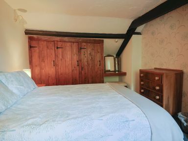 A bedroom with a bed and wardrobe at The Old Bakery South Perrott near Mosterton