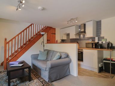 A living room with a sofa and kitchen units at Jasmine Cottage South Perrott near Mosterton